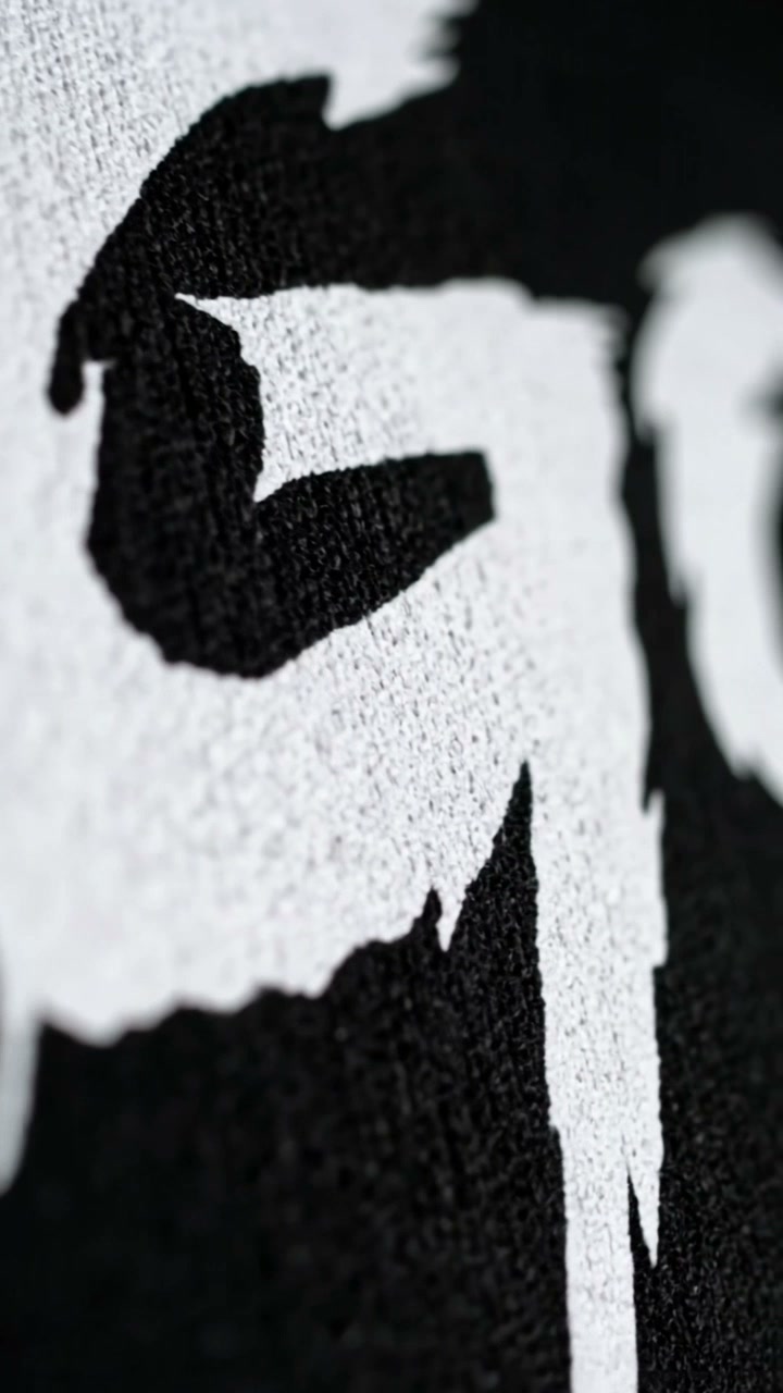 Macro of the white GOTA lettering on the black tee